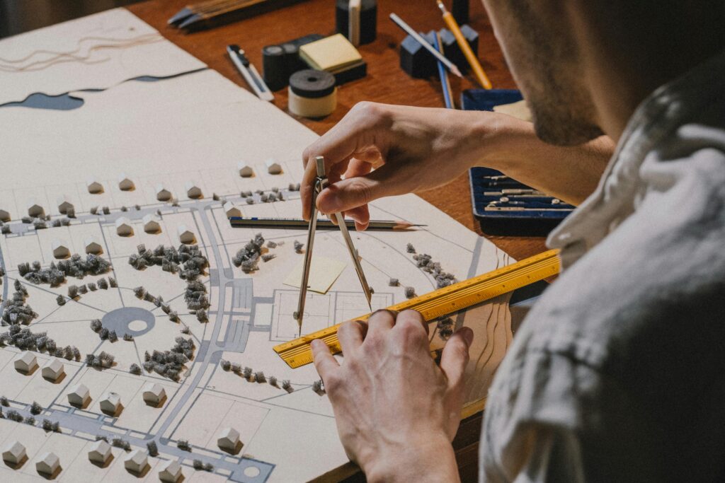 Architect meticulously working on a detailed scale model with compass and ruler.